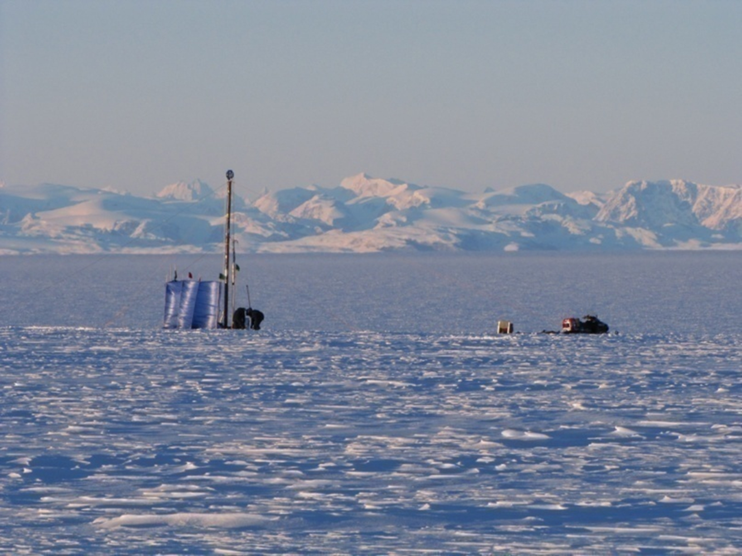 Drill rig used to extract firn cores from within the Greenland firn aquifer.  One of the snowmobiles used in the 300 km traverse of the ice sheet to reach the drill site.  Pictured, Clément Miège (co-author and PhD student University of Utah), and Terry Gacke (Ice Drilling Design and Operations).