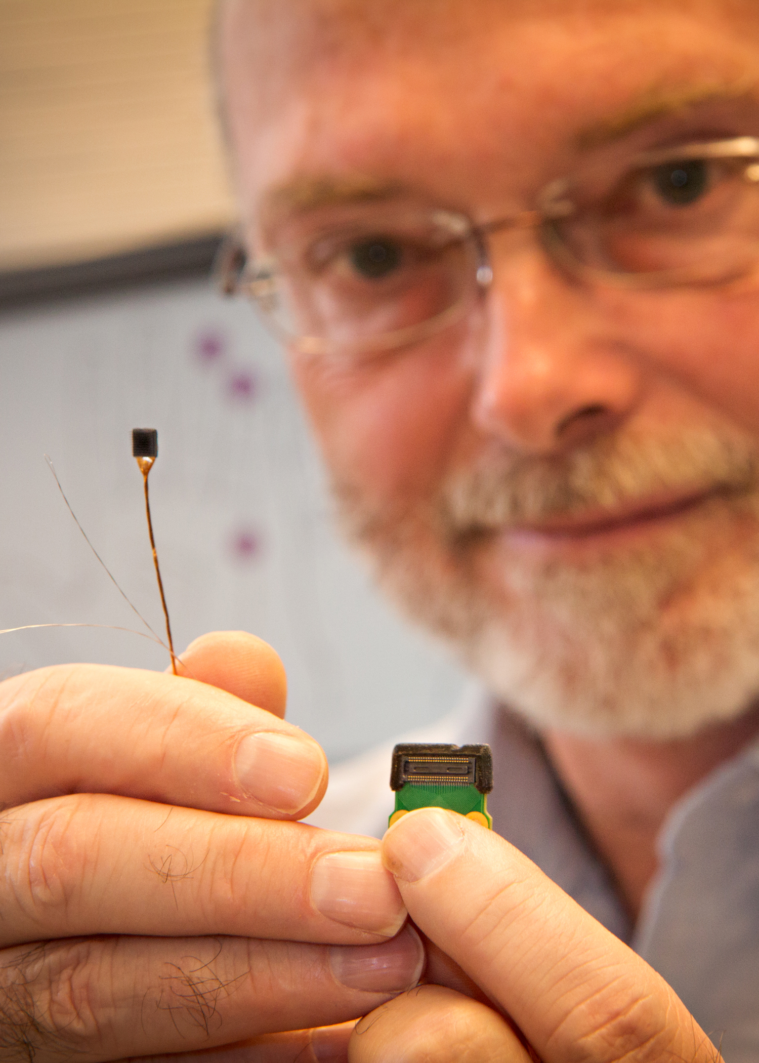 University of Utah bioengineering associate professor Gregory Clark holds up the tiny Utah Slanted Electrode Array, a neural interface that connects with nerves in an amputee’s arm. The array reads signals from the brain, telling an advanced prosthetic hand how to move. Likewise, the neural interface delivers meaningful sensations of touch and movement from the hand back to the brain. University of Utah researchers have received $1.4 million to further develop the implantable neural interface as part of a project for an advanced prosthetic hand that can move by the person’s thoughts.