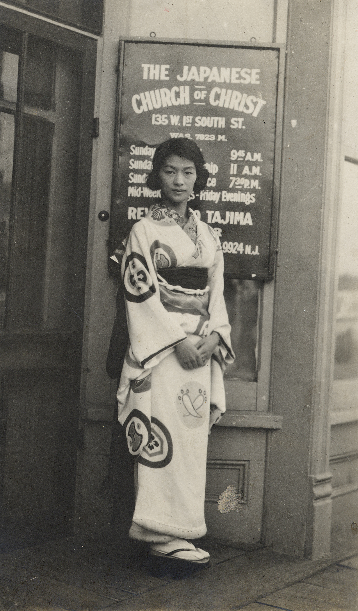 An unidentified woman stands in front of the original location of the Japanese Church of Christ in Salt Lake City’s Japantown, circa early 1920’s.