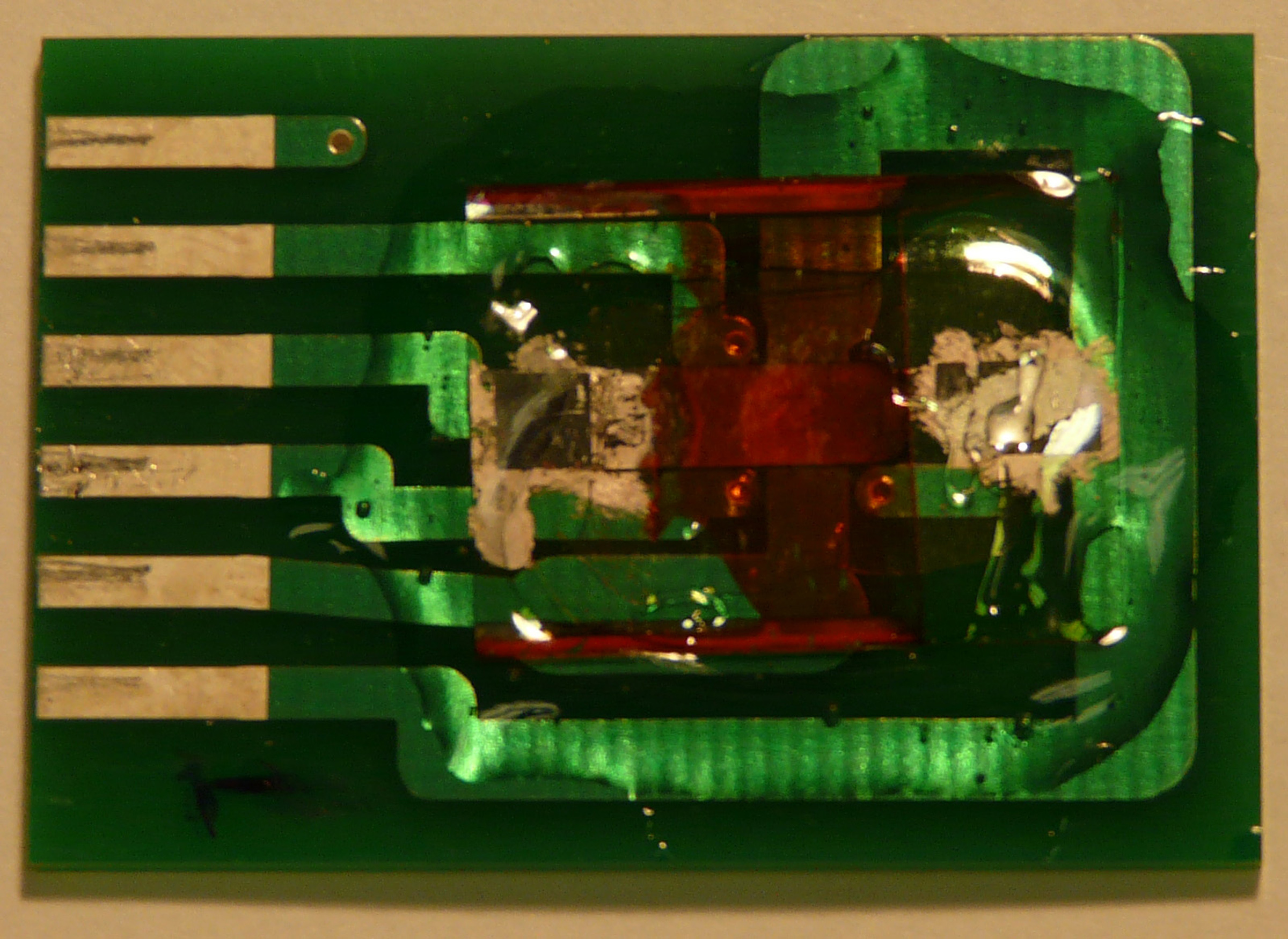 An inexpensive and highly accurate “spintronic” magnetic field sensor developed at the University of Utah is shown here. The entire device, on a printed circuit board, measures about 0.8 inches by 1.2 inches. But the part that actually detects magnetic fields is the reddish-orange thin-film semiconductor – essentially “plastic paint” – near the center-right of the device.