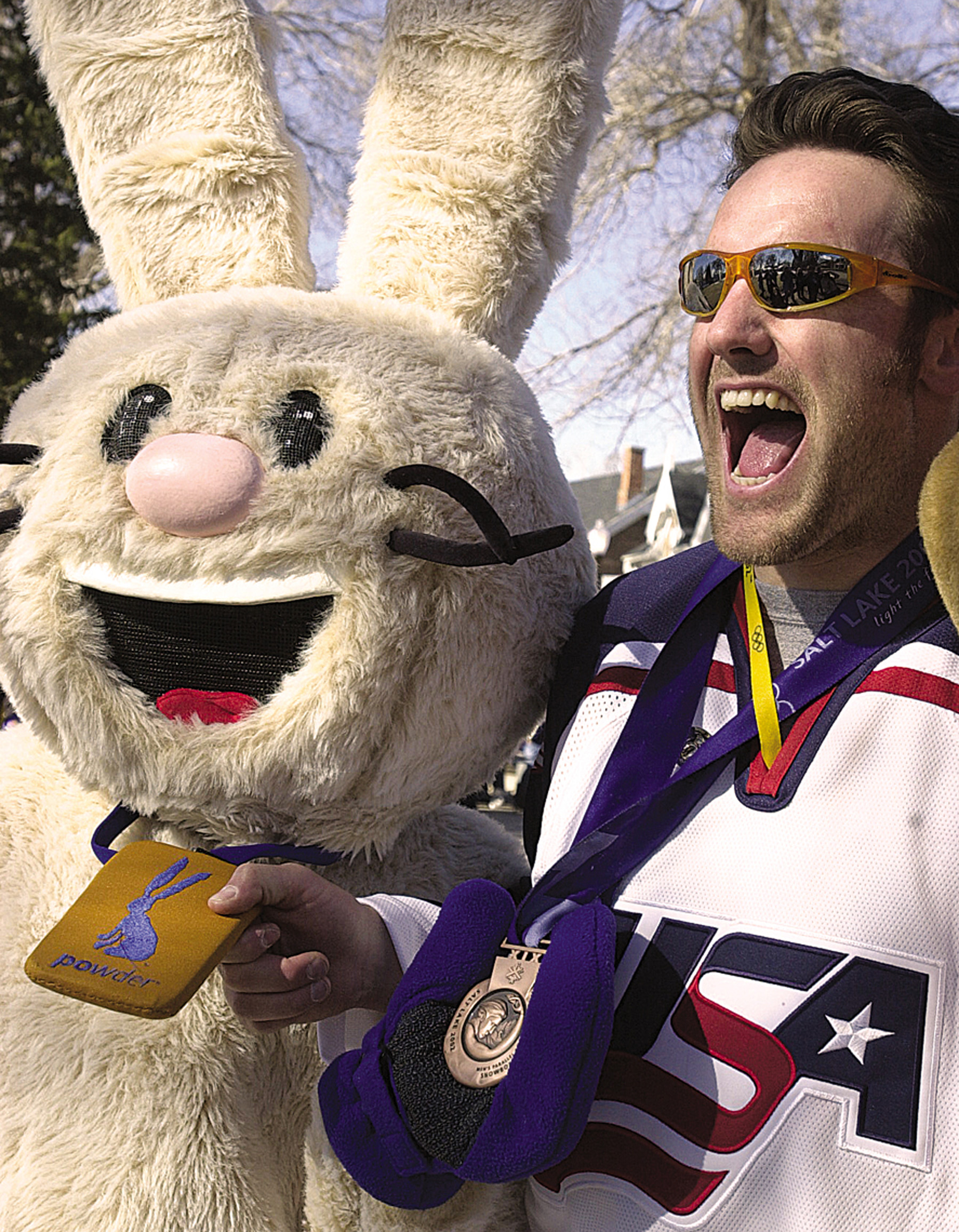 Powder poses with an athlete during a celebration at the Olympic Village.