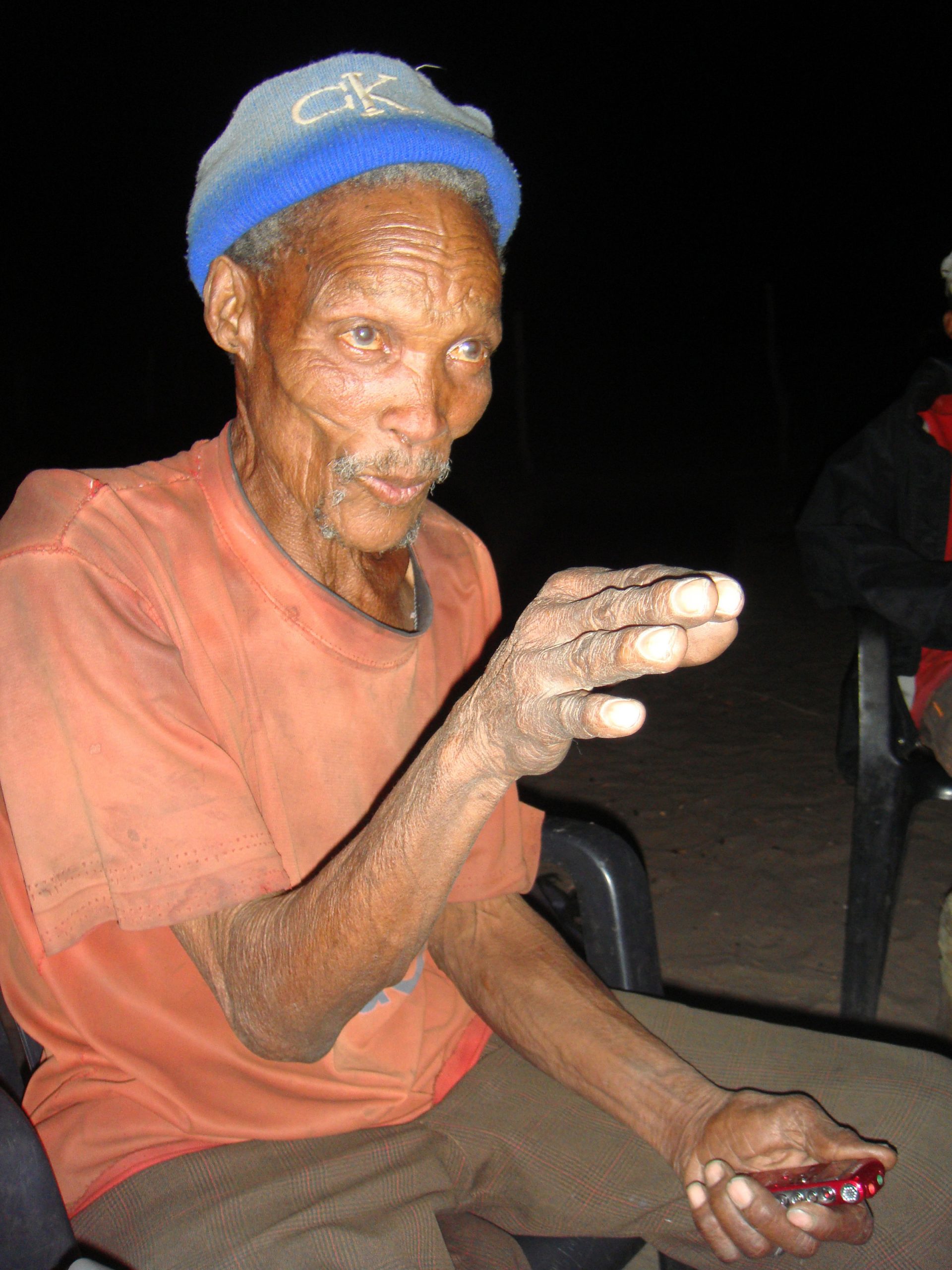 A !Kung Bushman, sporting a Calvin Klein hat, tells stories at a firelight gathering in Africa’s Kalahari Desert. University of Utah anthropologist Polly Wiessner has published a new study of the Bushmen suggesting that when firelight extended the day for human ancestors, stories told around the campfire helped stimulate human mental, social and cultural development.