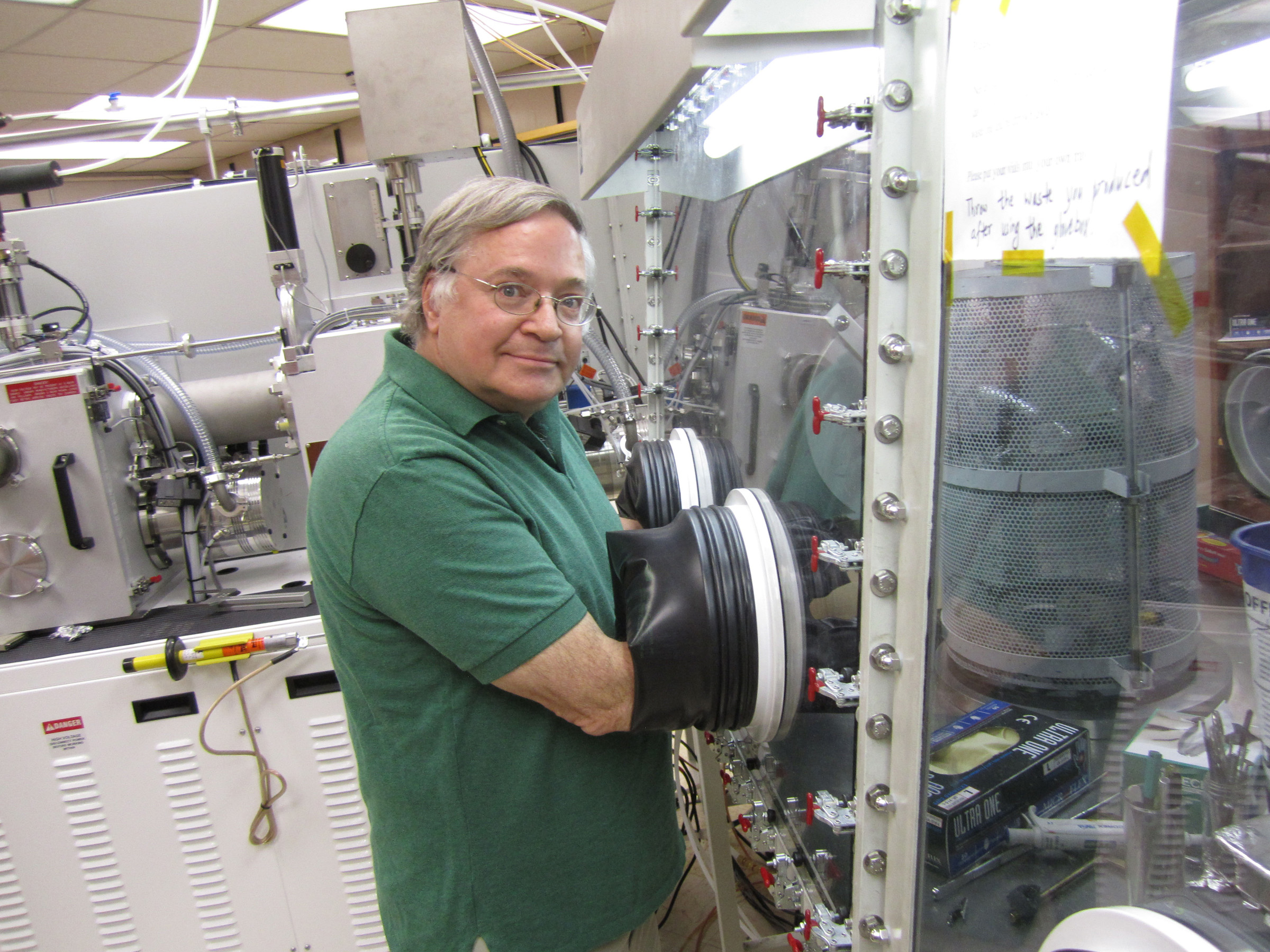 University of Utah physicist Z. Valy Vardeny works in a glove box where light-emitting polymers are studied under clean conditions. Vardeny and colleagues have inserted platinum atoms into an organic semiconductor, creating polymers that can be “tuned” to emit light of different colors – a step toward a new kind of organic light-emitting diode, or OLED, that can emit truly white light and be used in future light bulbs.