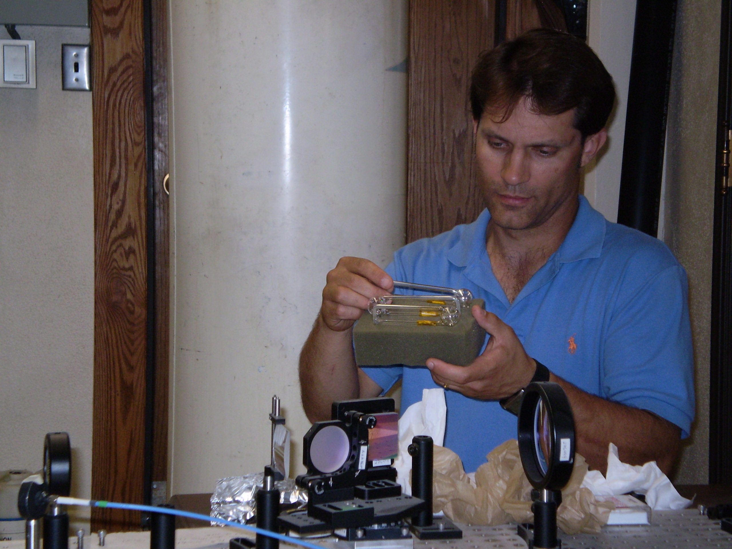 University of Utah physicist Brian Saam examines tubes of invisible xenon gas that he used to explore the relationship between chaos theory and modern quantum physics.