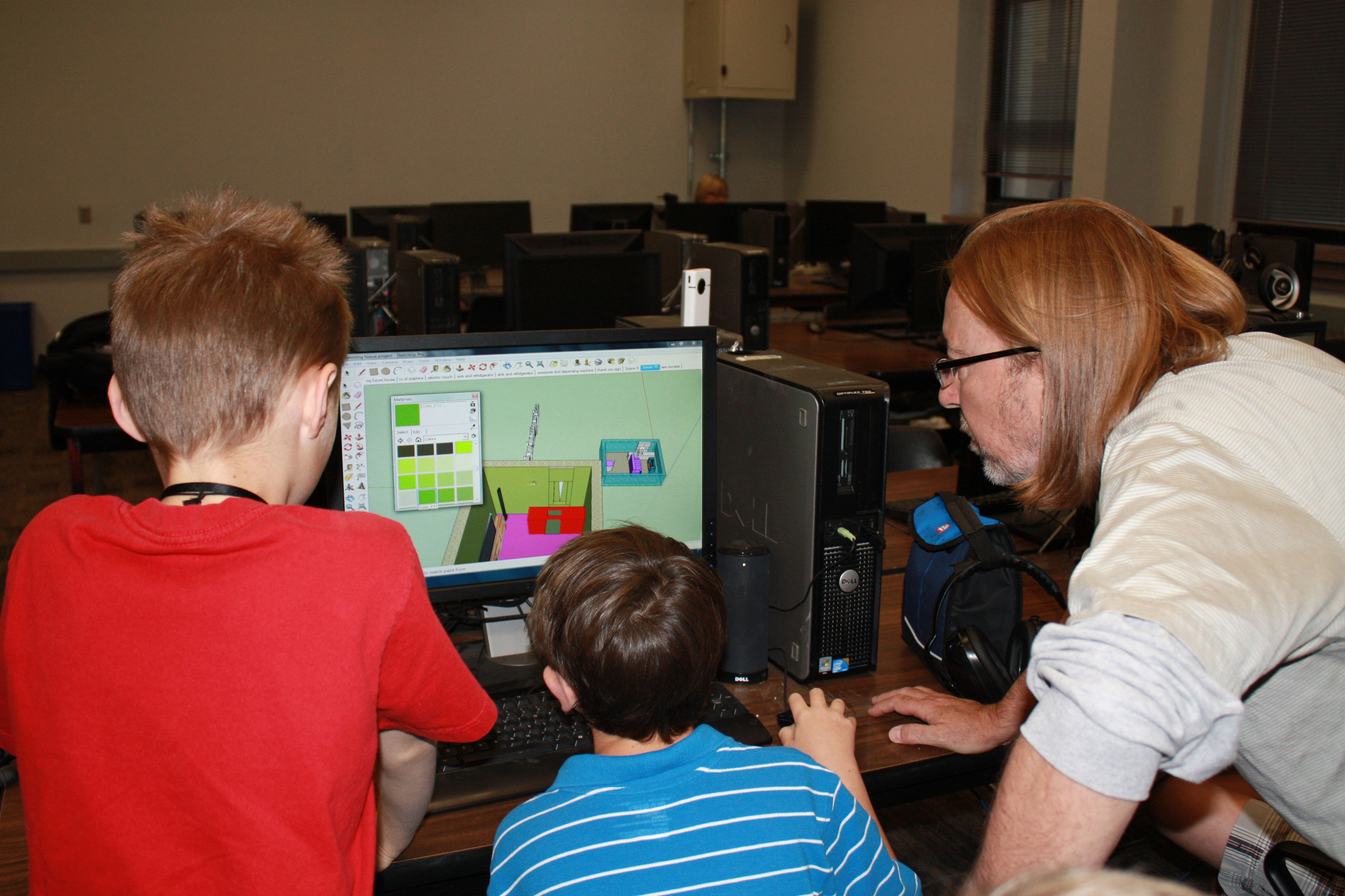 The University of Utah has teamed with Google to teach kids with autism how to use Google’s 3D modeling software called SketchUp. A new study from the university shows that in developing the workshops designed to teach needed job skills, Utah researchers found extra benefits, such as stronger interpersonal relationships and greater confidence due, in large part, to a focus on the kids’ talents instead of their disorder. Here, certified SketchUp instructor Steve Gross teaches two children how to use the software.