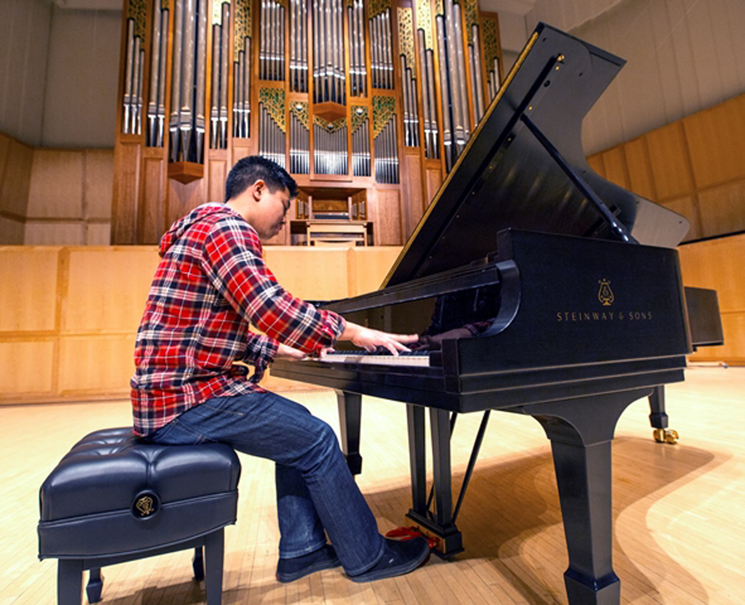 A lucky student is first to play the new Steinway Concert Grand in the Libby Gardner Concert Hall on the U campus.