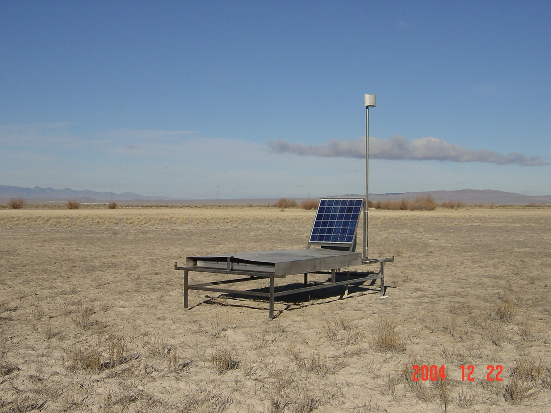 A table-like scintillation detector sits in the Utah desert, powered by a solar panel. A grid of 564 such devices will be installed in a 400-square-mile area west of Delta, Utah, as part of the $17 million Telescope Array cosmic ray observatory. The scintillation detectors will measure "air shower" particles that hit Earth after incoming cosmic rays smash into gas particles in Earth's atmosphere.